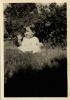 June Smith waving, about 1 year old, sitting on grass, about 1924